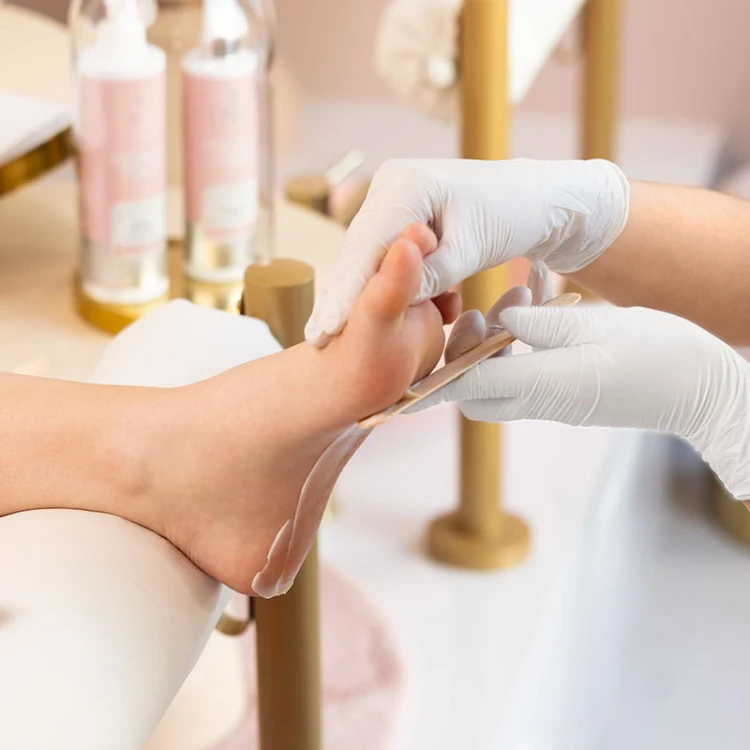Aplikacja maści ochronnej z oliwą ozonowaną CRACKED HEEL PROTECTOR Pharm Foot na skórę stopy podczas zabiegu