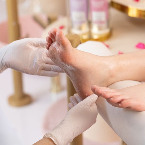 Peeling stóp na zabiegu pedicure, masaż w rękawiczkach